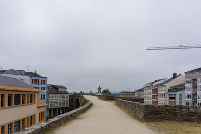 Street amidst buildings against sky in the roman wall of lugo