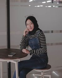 Portrait of teenage girl sitting on seat 