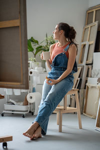 Young woman sitting on chair at home