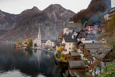 Houses by lake in town against sky