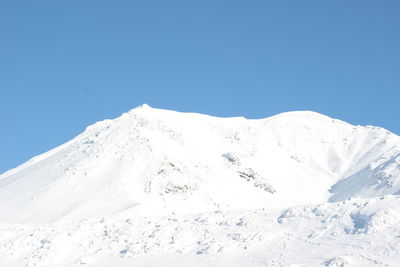 Scenic view of snowcapped mountains against clear blue sky