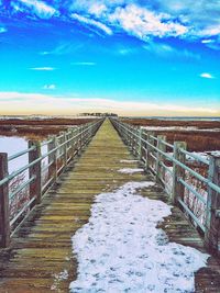 Pier on sea against cloudy sky