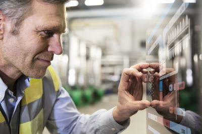 Man using touchscreen device in industrial plant