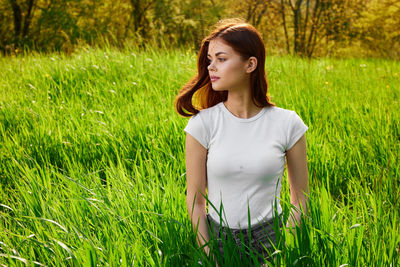 Young woman standing on grassy field