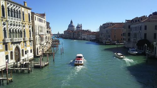 Boats in canal amidst buildings in city