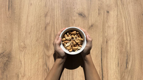 Cropped hand of woman holding food on table