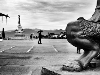 Cropped image of statue by people at piazzale michelangelo in rain