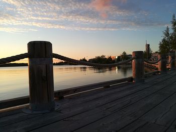 Pier in sea at sunset