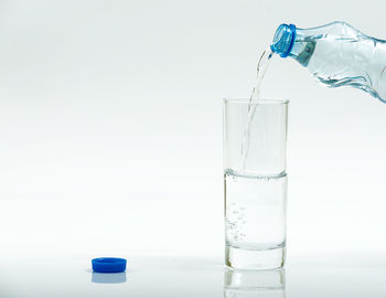 Close-up of glass bottle on table against white background