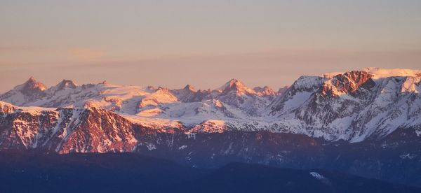 Scenic view of snowcapped mountains against sky during sunset