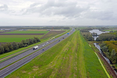 High angle view of road amidst field against sky