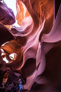 People standing amidst rock formations at antelope canyon