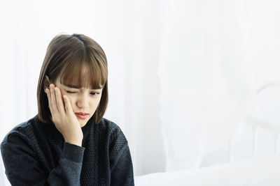 Woman with toothache sitting at home