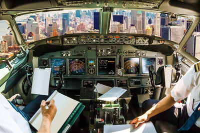 Pilots sitting in cockpit over city