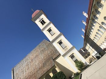 Low angle view of buildings against clear blue sky