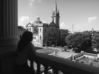 Woman by temple against sky