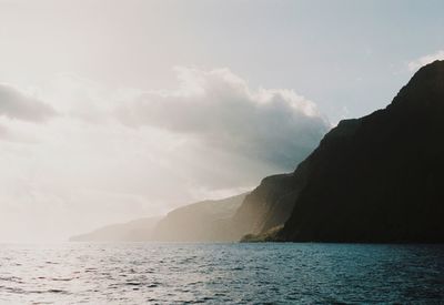 Scenic view of sea and mountains against sky