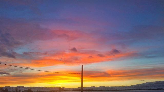 sunset, sky, orange color, scenics, beauty in nature, tranquility, tranquil scene, cloud - sky, silhouette, mountain, nature, cloud, landscape, idyllic, dramatic sky, power line, low angle view, electricity pylon, cloudy, no people