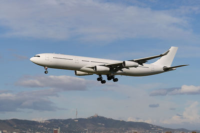 Airplane flying over mountains against sky