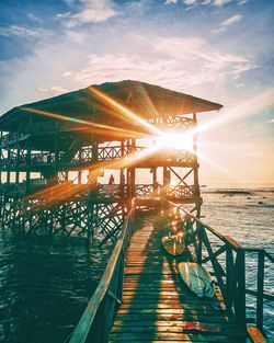 Pier over sea against sky during sunset