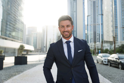 Portrait of smiling businessman standing in city