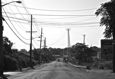 Electricity pylon against cloudy sky