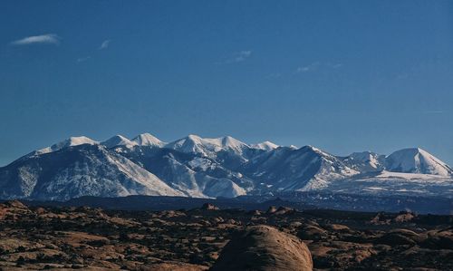 Scenic view of snowcapped mountains against blue sky