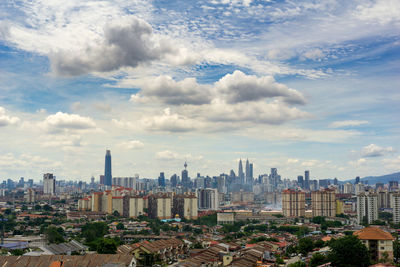 Aerial view of buildings in city against sky