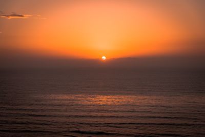 Scenic view of sea against orange sky