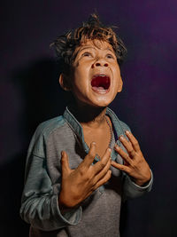 Midsection of boy standing against black background