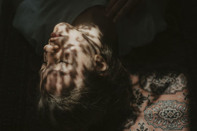 Portrait of young woman lying down on bed