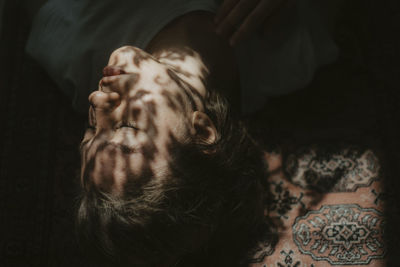 High angle view of young woman sleeping on bed