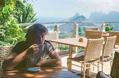 Man drinking coffee with a mountain view in rio de janeiro 