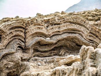 Close-up of rock formation on beach against sky