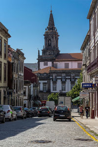 Cars on street against church in city