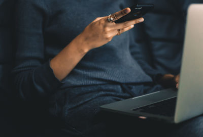 Midsection of man using mobile phone