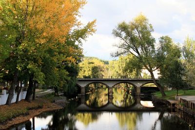 Arch bridge over lake against sky