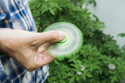 Midsection of man spinning fidget spinner