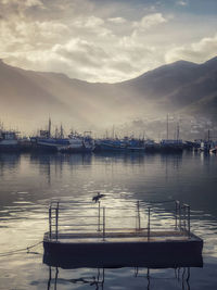 Sailboats moored against sky