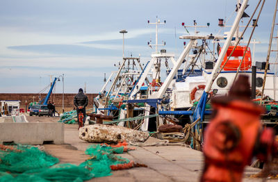 Boats moored at harbor against sky