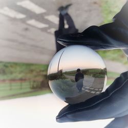 Close-up of hand holding glass with reflection