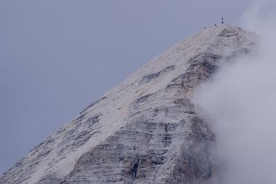 Low angle view of snowcapped mountain against clear sky