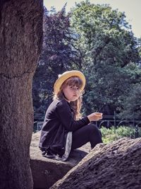 Girl sitting on rock in park