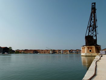 Buildings at waterfront against blue sky