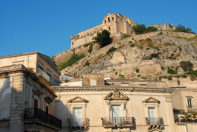 Low angle view of historical building against clear blue sky