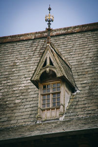 Low angle view of weather vane against sky