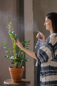 Woman looking at potted plant