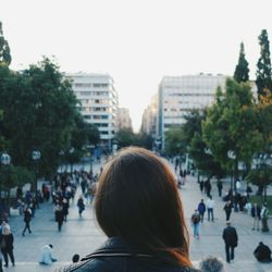 Rear view of woman with crowd on street in background