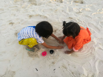 High angle view of children playing with toy on sand