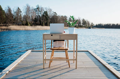 Travelling desk and laptop on a pier at the beach at sunset